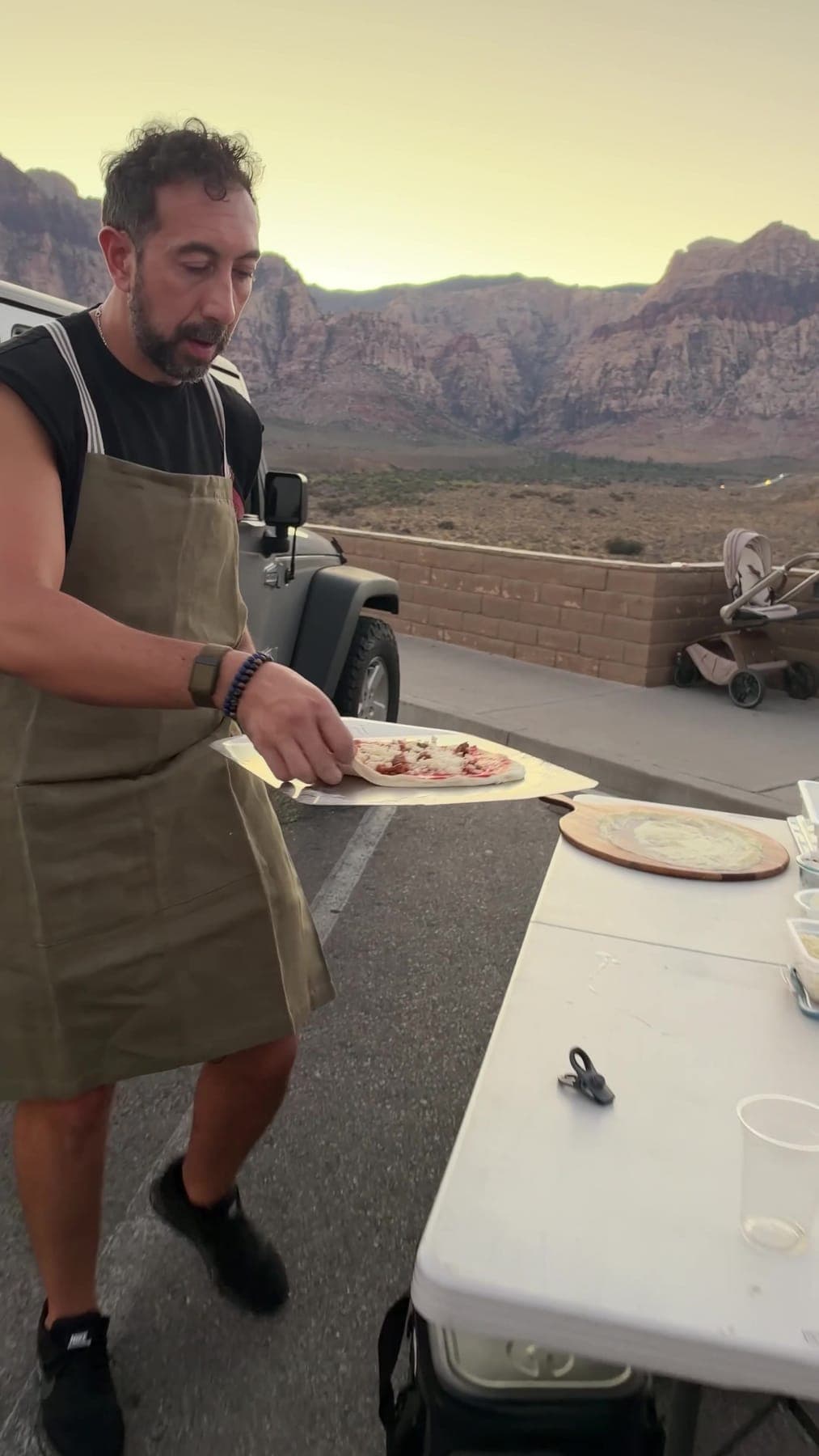 Alessio in his apron with a pizza on the peel