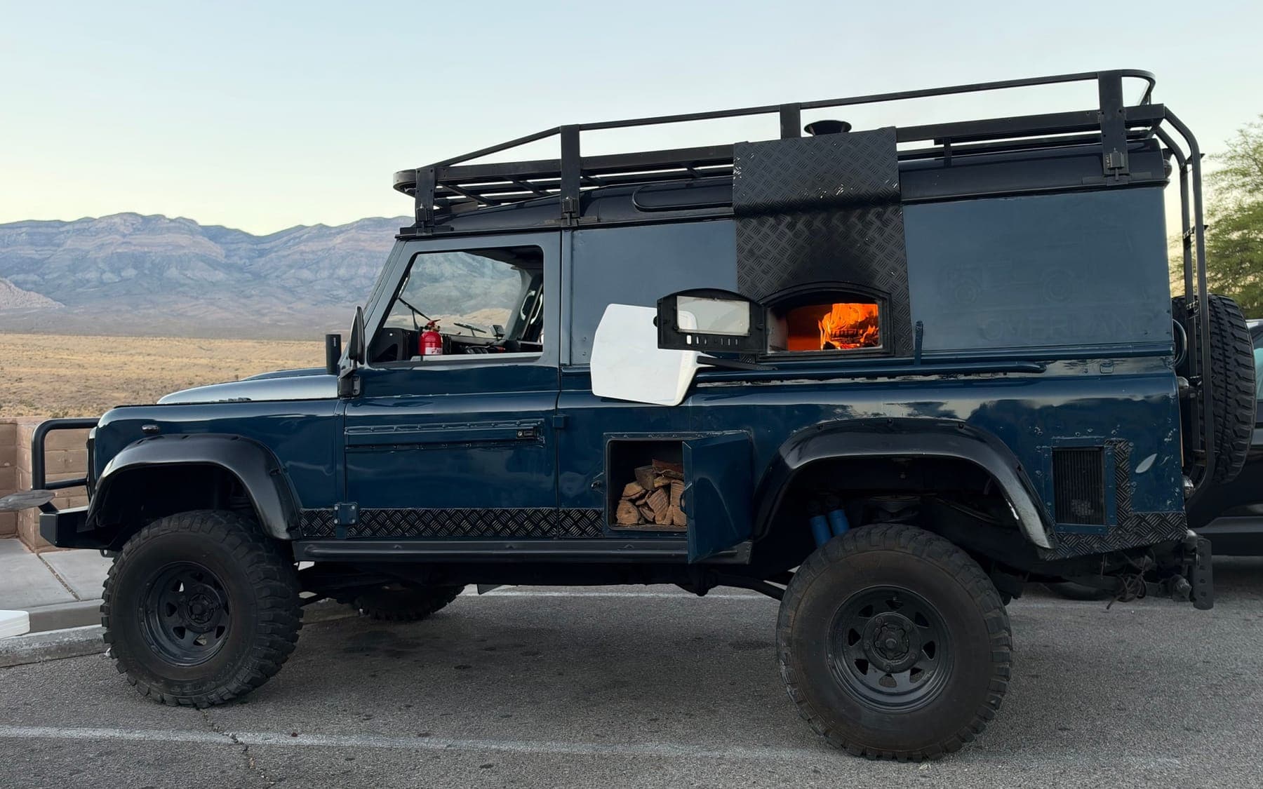 The petrol-blue Defender with the oven lit, Red Rock Canyon behind